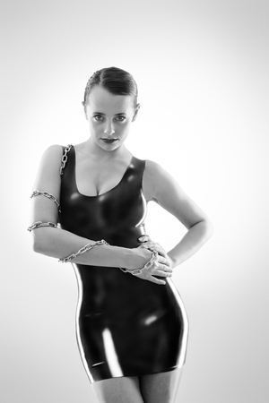 Studio black and white image of young woman wearing latexの写真素材
