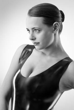 Studio black and white image of young woman wearing latexの写真素材