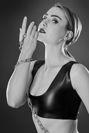 Studio black and white image of young woman wearing latexの写真素材