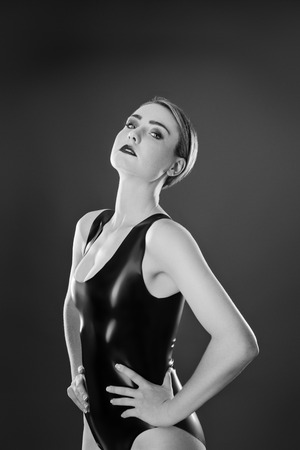 Studio black and white image of young woman wearing latexの写真素材