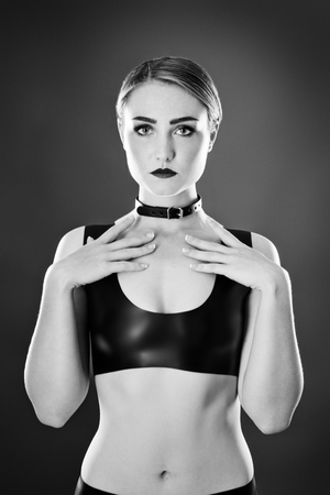 Studio black and white image of young woman wearing latexの写真素材