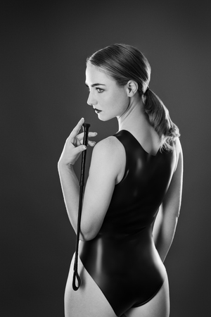 Studio black and white image of young woman wearing latexの写真素材