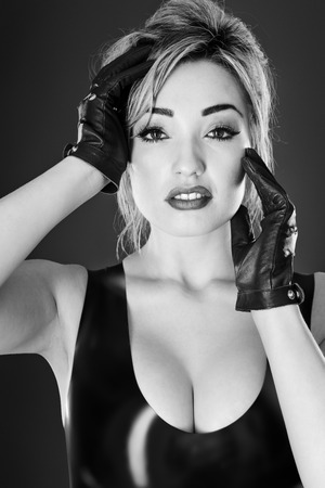 Studio black and white image of young woman wearing latexの写真素材