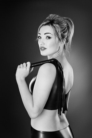 Studio black and white image of young woman wearing latexの写真素材