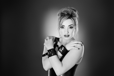 Studio black and white image of young woman wearing latexの写真素材
