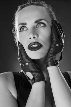 Studio black and white image of young woman wearing latexの写真素材
