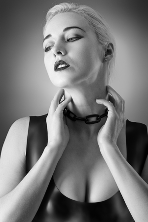 Studio black and white image of young woman wearing latexの写真素材