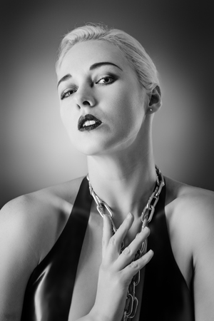 Studio black and white image of young woman wearing latexの写真素材