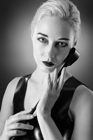 Studio black and white image of young woman wearing latexの写真素材