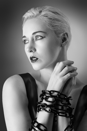 Studio black and white image of young woman wearing latexの写真素材
