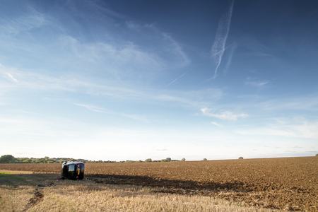 car on its rolled onto its side in a field after going to fast around cornerの写真素材