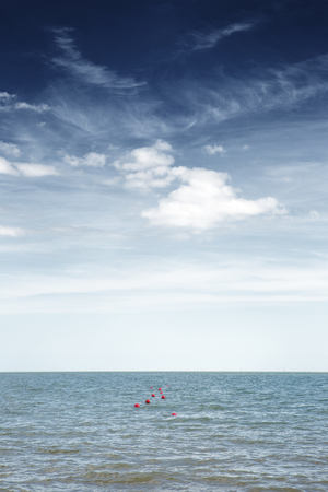 sea scape image looking out to sea from england at red buoy bobbing up and downの写真素材