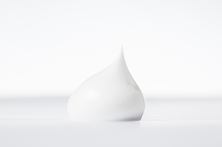close up detail of single drop of beauty cream on white back groundの写真素材