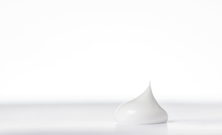 close up detail of single drop of beauty cream on white back groundの写真素材