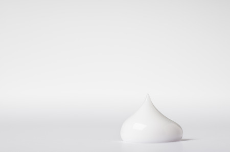 close up detail of single drop of beauty cream on white back groundの写真素材