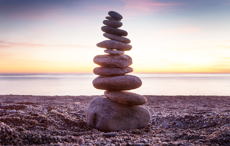 Rock balancing or stone balancin,  naturally balanced on a beach with the sea behindの写真素材