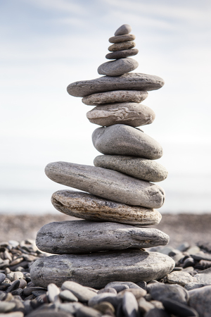 Rock balancing or stone balancin,  naturally balanced on a beach with the sea behindの写真素材