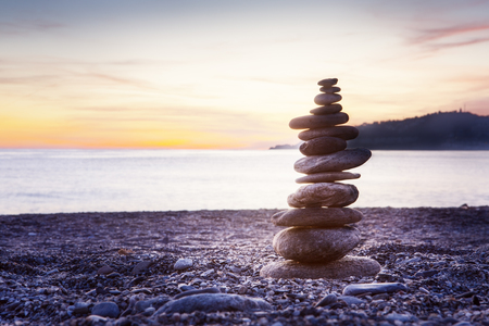 Rock balancing or stone balancin,  naturally balanced on a beach with the sea behindの写真素材