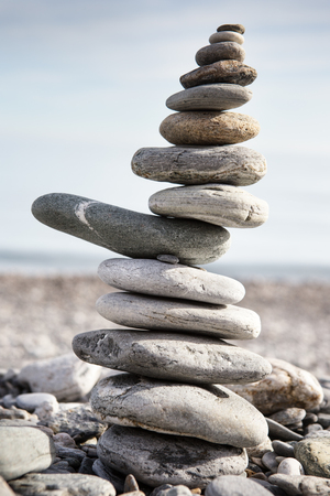 Rock balancing or stone balancin,  naturally balanced on a beach with the sea behindの写真素材