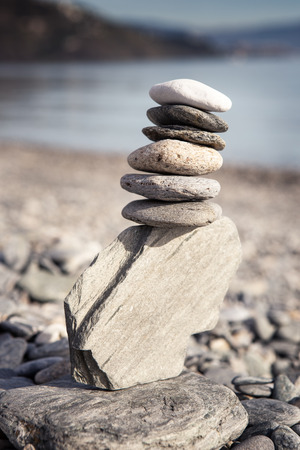 Rock balancing or stone balancin,  naturally balanced on a beach with the sea behindの写真素材