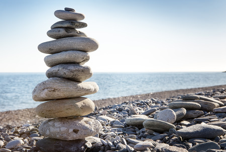 Rock balancing or stone balancin,  naturally balanced on a beach with the sea behindの写真素材