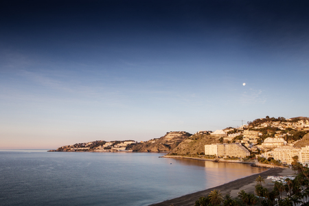 Landscape shot of Almunecar with the moon in the skyの写真素材