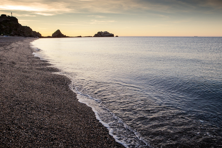 sunrise on a beach in costa de tropical Almunecar spain with the large cross of  Penones del Santo in the backgroundの写真素材