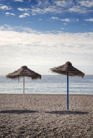 two lonely beach umbrella in almunecar spain by the seaの写真素材