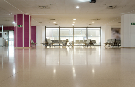 chairs by a window of a airport terminal gate waiting to flightの写真素材