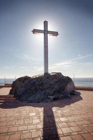 A large cross of  Penones del Santo in costa de tropical Almunecar spain, with the sun behind the crossの写真素材