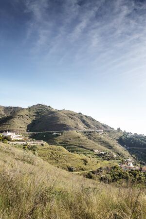 hill side view in almunecar spain of houses and roadsの写真素材