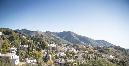 hillside town of mijas with lots of whitewash building and homes build into the hillsideの写真素材