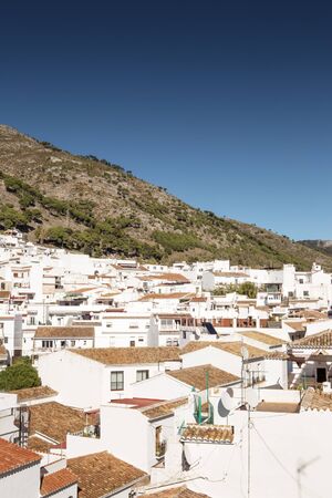 hillside town of mijas with lots of whitewash building and homes build into the hillsideの写真素材