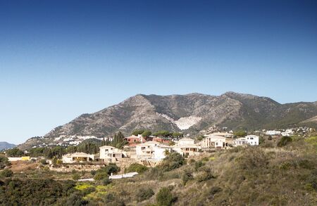 hillside town of mijas with lots of whitewash building and homes build into the hillsideの写真素材