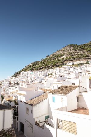 hillside town of mijas with lots of whitewash building and homes build into the hillsideの写真素材