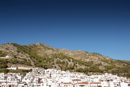 hillside town of mijas with lots of whitewash building and homes build into the hillsideの写真素材