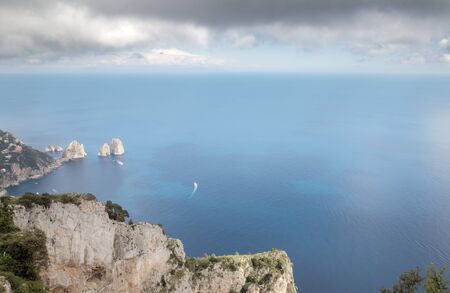 view point on mount solaro looking down at the three towering rock formations of Faraglioni の写真素材