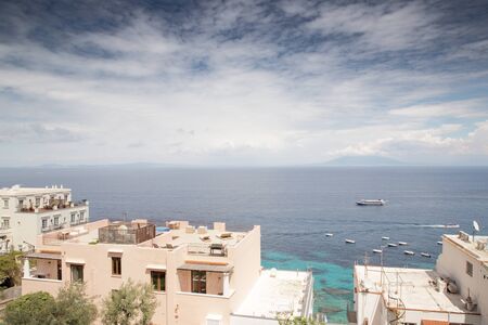 roof top image of building on the island of capri in italy with a view of mount vesuvius in the background across the seaの写真素材