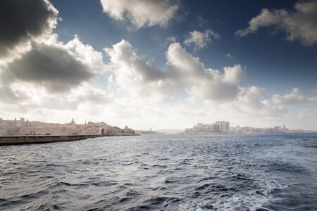 seascape of Sliema in the background and in the forgound the footbridge leading from the foreshore of Fort Saint Elmo to the light houseの写真素材