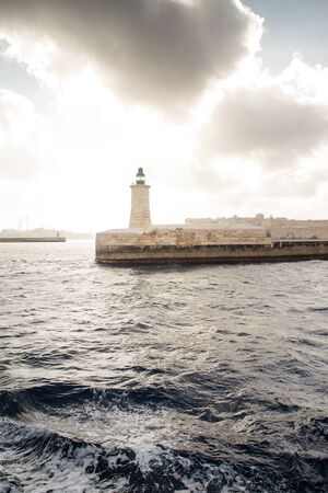 seascape image of the lighthouse at the end of the pier in Valletta malta の写真素材