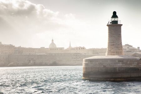 seascape image of the lighthouse at the end of the pier in Valletta malta の写真素材