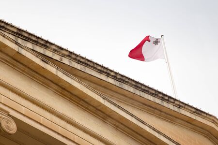 malta flag flying on a building の写真素材