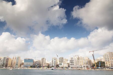 seafront along the coast of Sliema in malta with a lot of building work being done の写真素材