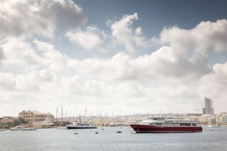 boat on the water outside valletta the capital of maltaの写真素材