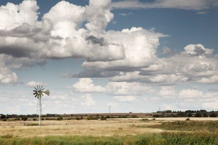 landscape image with a windmill in the foregroundの写真素材