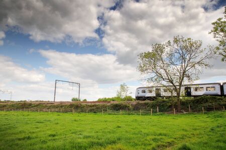train going past set in a beautiful landscape image of the essex countrysideの写真素材