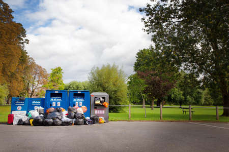 stacked up rubbish by recycle bin that need collecting