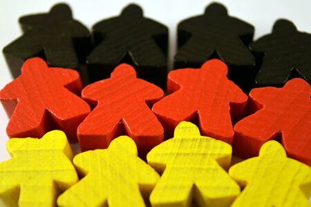 German flag made of black, red and yellow meeples. Euro board game pieces. Strategy games.