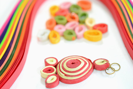 Quilling paper and craft activities. Closeup of ear ring made of quilling paper.の写真素材