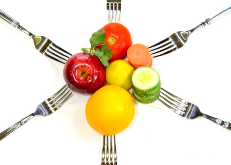 Healthy diet food on a white background. apples, orange, green leaves, spinach, carrot, cucumber, tomato and lemon with forkの写真素材